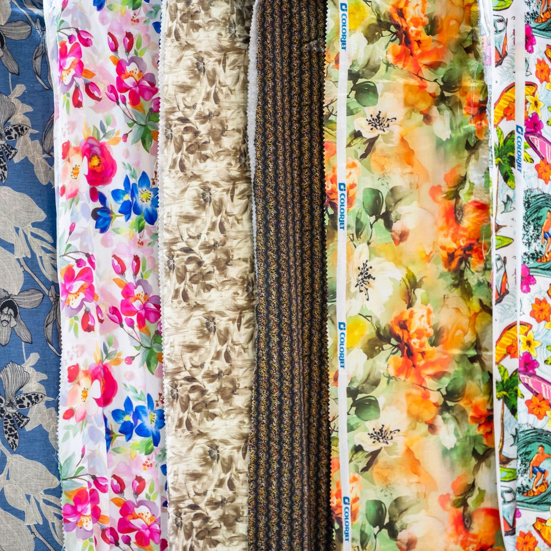 Lengths of digitally printed floral fabrics hanging side by side