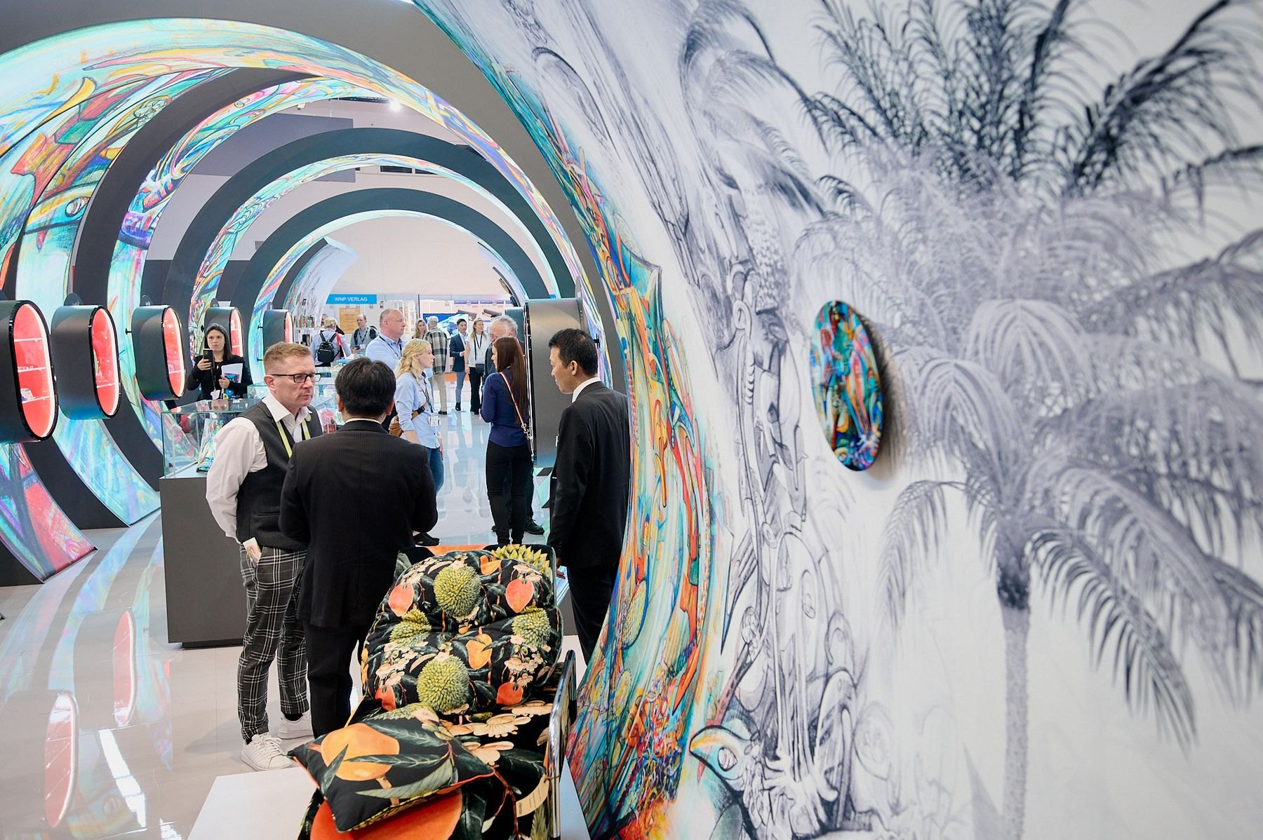 Visitors walking through a tunnel of printed fabric at the exhibition