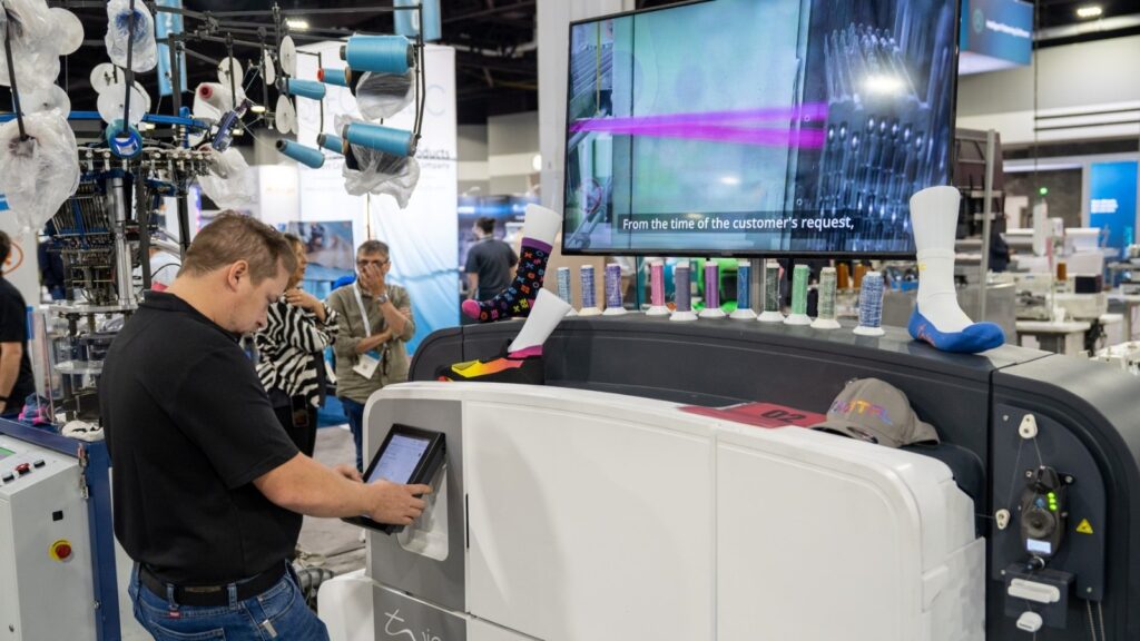 Visitor operating a knitting machine at Texprocess Americas